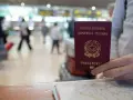 W podróży na Maderę, czy do Madery potrzebny jest paszport? W ręku włoski paszport, na tle lotniska.