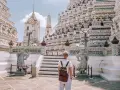 Młody turysta z plecakiem podziwia majestatyczną świątynię Wat Arun w Bangkoku. Czy Bangkok jest bezpieczny? Tak, zwłaszcza w takich pięknych i spokojnych miejscach.