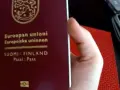 Dłoń trzyma paszport Finlandii. Czy do Finlandii trzeba mieć paszport? Tak, jeśli nie jesteś obywatelem UE/Schengen.
