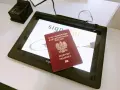 Polski paszport na ekranie tabletu w biurze paszportowym w Poznaniu. Obok skaner linii papilarnych.