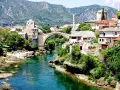 Mostar, Bośnia i Hercegowina. Tłumy ludzi spacerują po Starym Moście, a turkusowa rzeka Neretwa płynie poniżej. Czy Bośnia i Hercegowina jest bezpieczna? Tak, to piękny kraj.