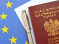 Paszport RP i długopis na tle flagi UE. Planujesz podróż? Sprawdź informacje w biurze paszportowym Łomża.