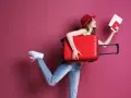 Kobieta z walizką i paszportem zastanawia się, ile kosztuje dodatkowy bagaż w Ryanair.