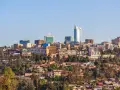 Widok na Kigali, Rwanda. Miasto rozwija się, a nowoczesne budynki górują nad zielonymi wzgórzami. Czy Rwanda jest bezpieczna? Obraz sugeruje spokój i postęp.