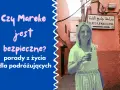 Kobieta w Marrakeszu, przy znaku Place Djemaa El Fna. Czy Maroko jest bezpieczne? Porady dla podróżujących.