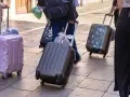 Ludzie z walizkami na kółkach, zastanawiający się, ile dopłata za bagaż Ryanair.