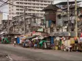 Uliczka w slumsach na Filipinach, gdzie życie toczy się wśród prowizorycznych domów i wszechobecnego prania. Czy w filipinach jest bezpiecznie? To pytanie nabiera nowego znaczenia w takich miejscach.