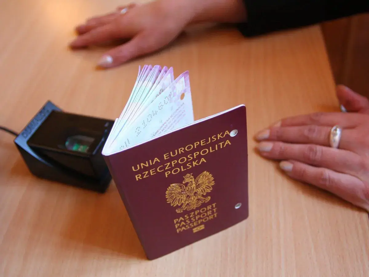 Paszport polski i skaner linii papilarnych na biurku. Dowiedz się, jak wyrobić paszport w Łodzi.
