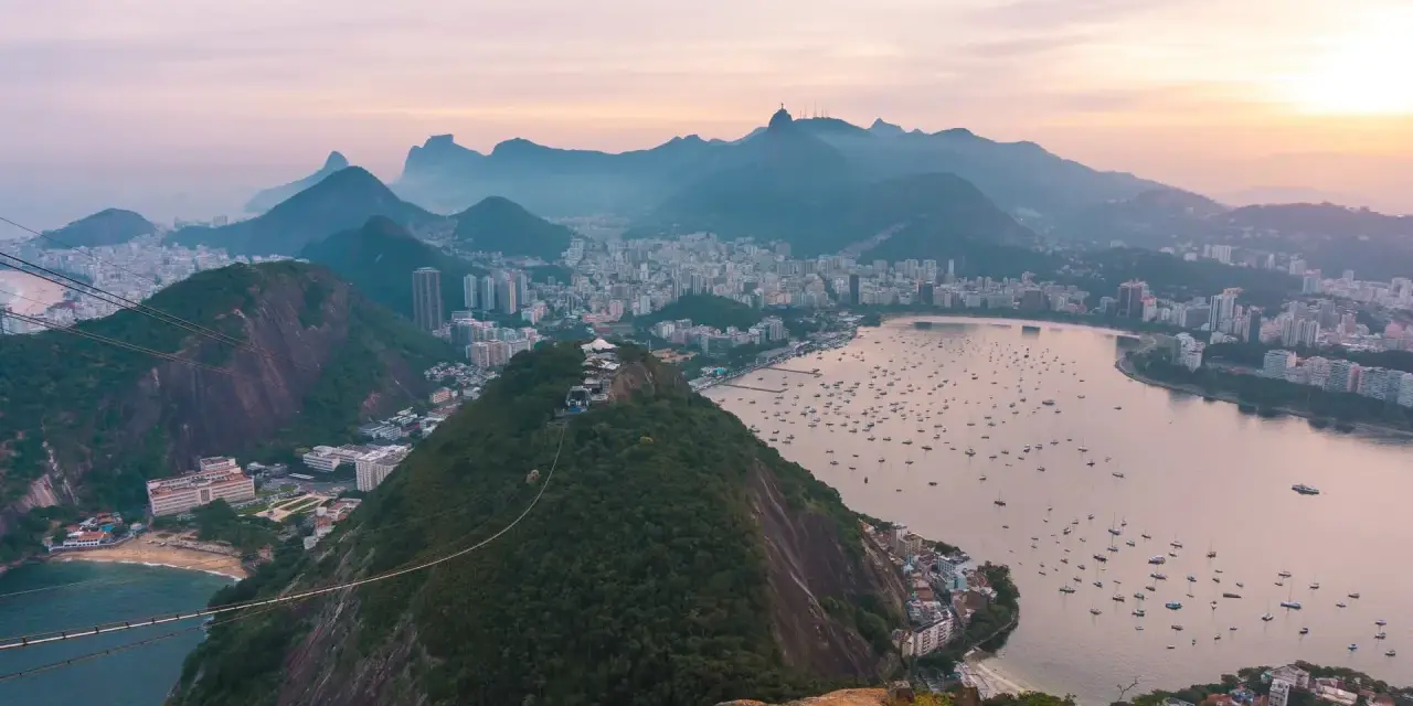 Widok na Rio de Janeiro z góry. Miasto, zatoka pełna łodzi i góry. Czy Brazylia jest bezpieczna? Widok zapiera dech w piersiach.