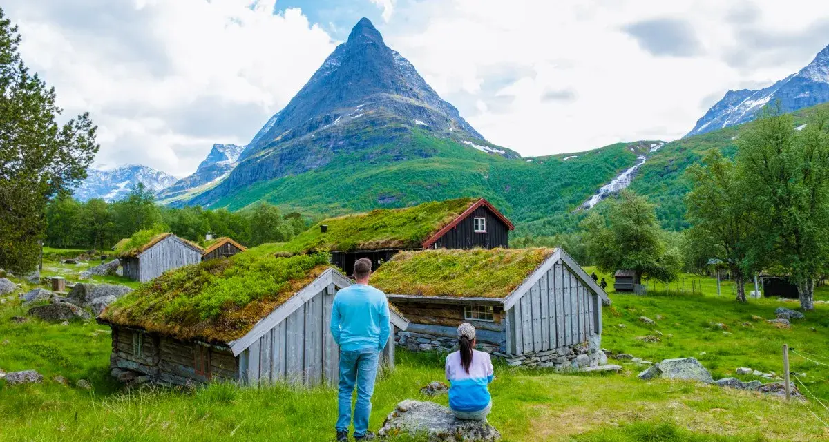 Para zwiedzająca norweskie chatki z zielonymi dachami. Czy do Norwegii można jechać na dowód osobisty? Tak, dowód wystarczy!