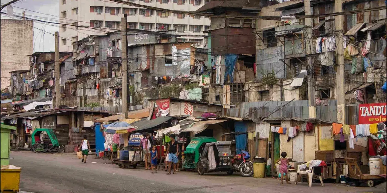 Uliczka w slumsach na Filipinach, gdzie życie toczy się wśród prowizorycznych domów i wszechobecnego prania. Czy w filipinach jest bezpiecznie? To pytanie nabiera nowego znaczenia w takich miejscach.