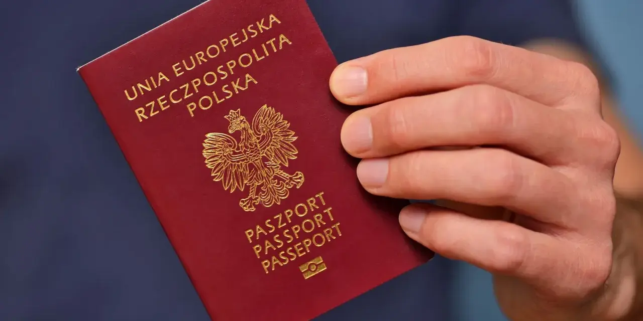 Dłoń trzyma polski paszport. Planujesz podróż i składasz wniosek o paszport w Gdyni?