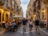 Ludzie spacerują i jedzą w restauracjach na ulicy w Valletcie. Czy podróż na Maltę jest bezpieczna? Tak, wygląda na to, że jest to bezpieczne i przyjemne miejsce.