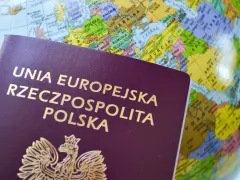 Polski paszport na tle globusa. Dowiedz się, jak złożyć wniosek o paszport przez internet, planując podróż.