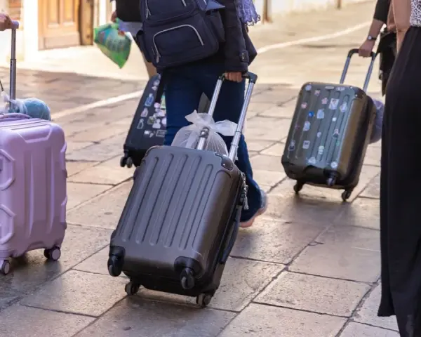 Ludzie z walizkami na kółkach, zastanawiający się, ile dopłata za bagaż Ryanair.