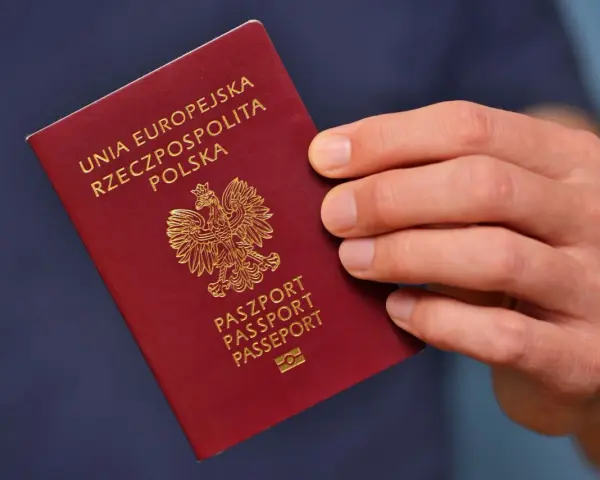 Dłoń trzyma polski paszport. Planujesz podróż i składasz wniosek o paszport w Gdyni?