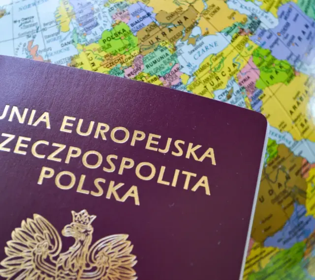 Polski paszport na tle globusa. Dowiedz się, jak złożyć wniosek o paszport przez internet, planując podróż.