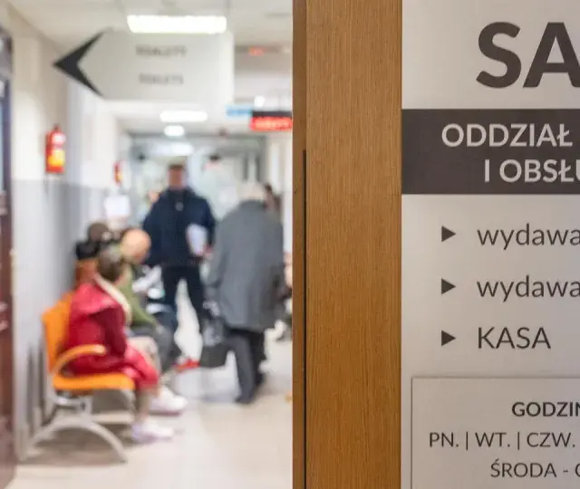 Korytarz urzędu paszportowego Bemowo. Ludzie czekają w kolejce do wydawania paszportów i kart pobytu.