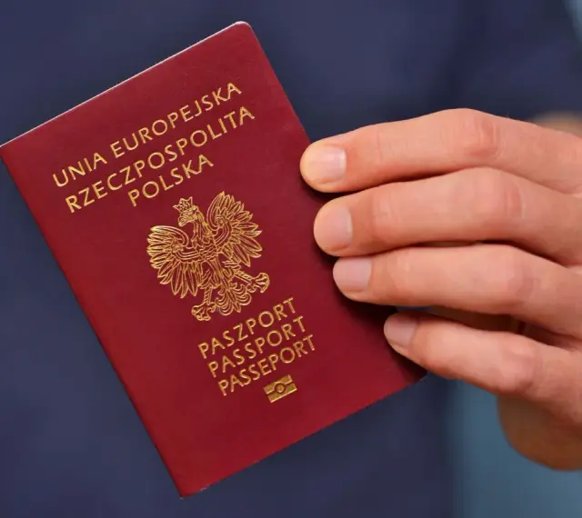 Dłoń trzyma polski paszport. Planujesz podróż i składasz wniosek o paszport w Gdyni?