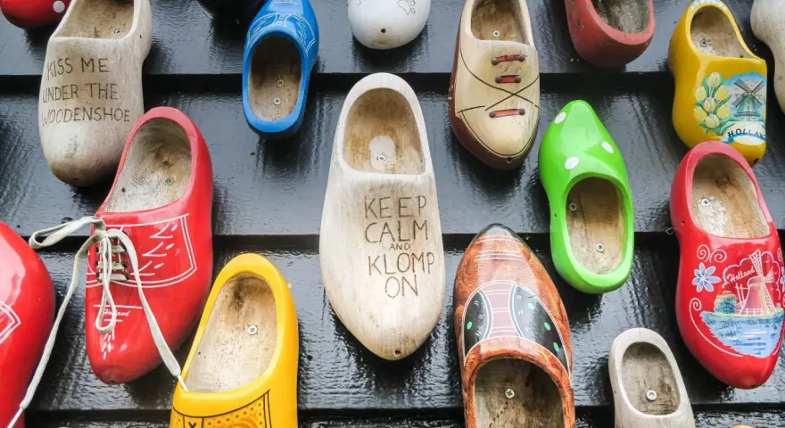 Kolorowe chodaki, idealne pamiątki z Holandii. Znajdziesz tu modele z napisami "Kiss me under the woodenshoe" i "Keep calm and klomp on".
