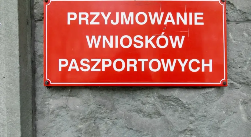 Czerwona tablica informuje o przyjmowaniu wniosków paszportowych. Czy żona może odebrać paszport męża? Sprawdź w urzędzie.