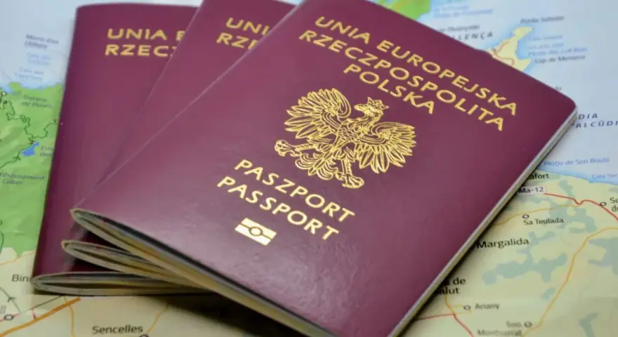 Trzy polskie paszporty leżą na mapie. Zastanawiasz się, ile czasu zajmuje zmiana paszportu przed podróżą?