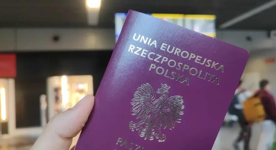 Polski paszport w dłoni, gotowy do podróży. Czy do UK potrzebny jest paszport? Tak, dla obywateli UE jest wymagany.
