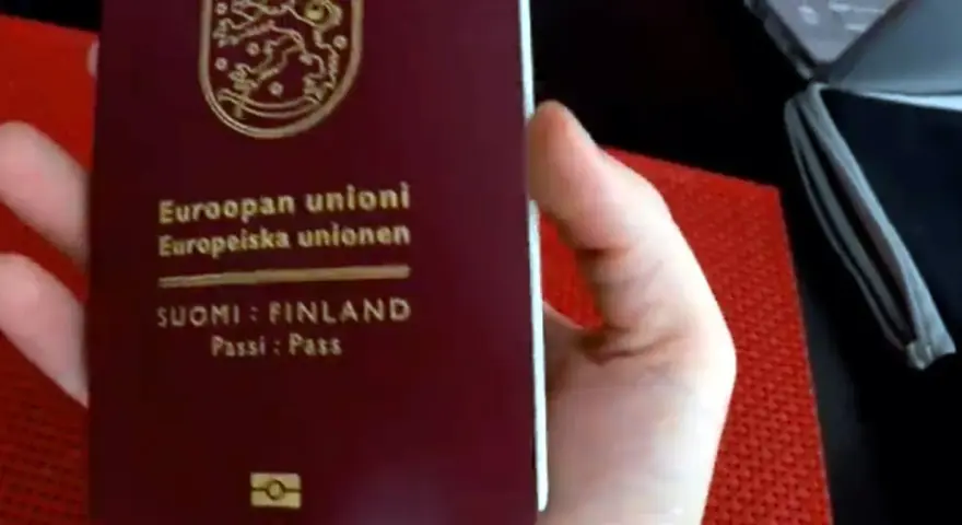 Dłoń trzyma paszport Finlandii. Czy do Finlandii trzeba mieć paszport? Tak, jeśli nie jesteś obywatelem UE/Schengen.
