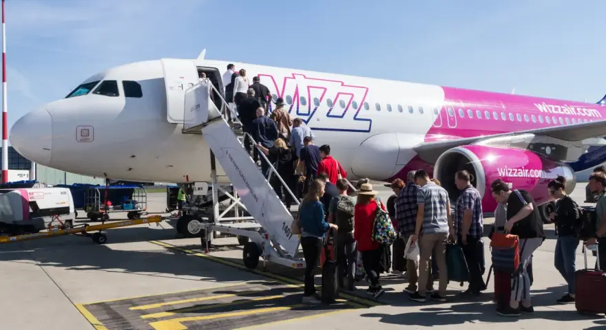 Pasażerowie Wizz Air wsiadają do samolotu. Zastanawiasz się, ile kosztuje bagaż Wizzair? Sprawdź cennik przed podróżą!